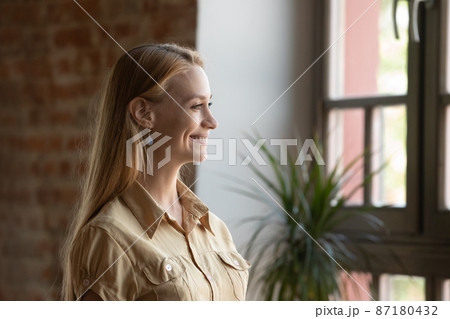 Smiling dreamy beautiful young woman looking in distance. Smiling dreamy beautiful young woman looking in distance. 87180432