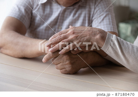Elderly couple holding hands with love and support close up 87180470