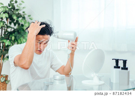 ドライヤーで髪を乾かす男性 87182434