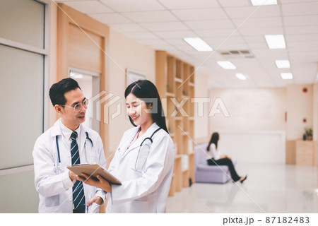 Asian doctor working and discuss for patient follow up treatment at hospital 87182483