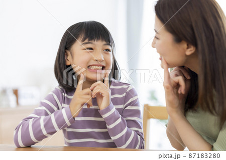 母親に歯を見せる女の子 87183280