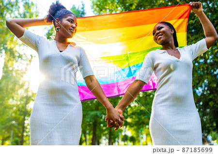 brazilian lesbian couple in white dress spending time together celebrating engagement in summer park outdoor 87185699