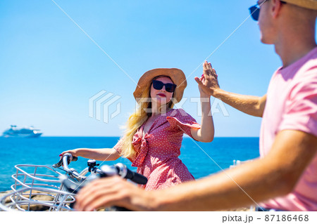 Couple on holiday with electric eco bicycles in sea vacations 87186468