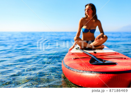 beautiful woman practising yoga on paddle sup surfboard beautiful woman practising yoga on paddle sup surfboard 87186469