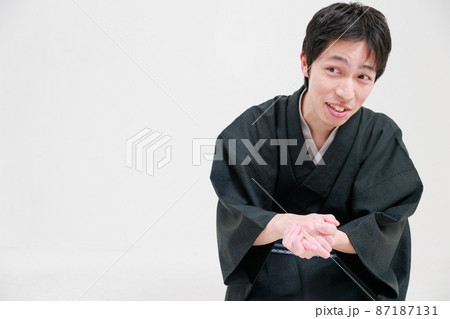 着物を着た男性がもみ手をしながら懇願する 着物を着た男性がもみ手をしながら懇願する 87187131