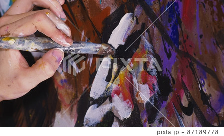 Artist designer draws an eagle on the wall. Craftsman decorator paints a picture with acrylic oil color brush. Close-up dark magic cinematic look. Artist designer draws an eagle on the wall. Craftsman decorator paints a picture with acrylic oil color brush. Close-up dark magic cinematic look. 87189778
