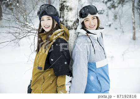 雪の降るスキー場でポーズをするスノボ女子　女子旅 87192816