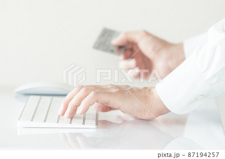 クレジットカード情報を入力する男性の手元 87194257