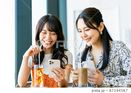 カフェでスマホを見る若い女性の友達 カフェでスマホを見る若い女性の友達 87194567