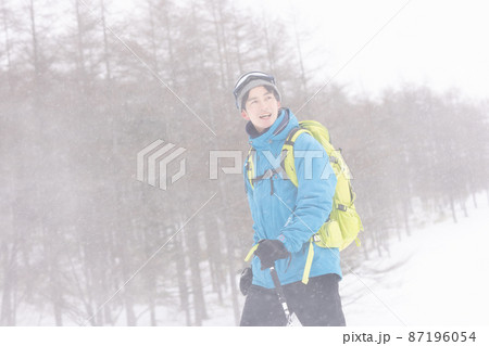 雪山を歩く若い男性 雪山を歩く若い男性 87196054