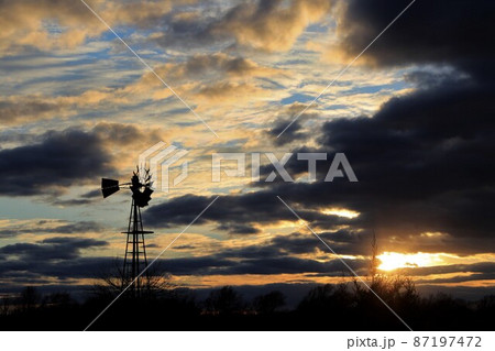 Kansas colorful Sunset with clouds and trees out in the country that's bright and colorful. 87197472