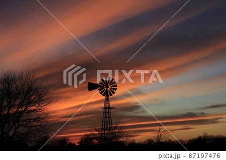 Kansas colorful Sunset with clouds and trees out in the country that's bright and colorful. 87197476