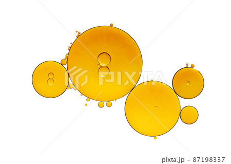 Golden yellow abstract oil bubbles or face serum isolated on white background. Oil bubbles macro photography. 87198337