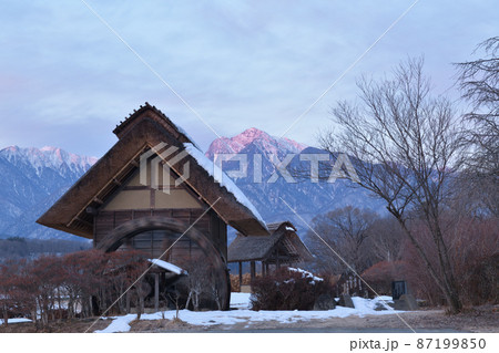 北杜市武川町、雪の積もった水車小屋と明け行く甲斐駒ケ岳 87199850
