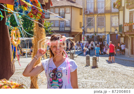 Young woman traveler with flower crown looking at camera 87200803