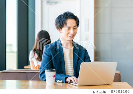 カフェでテレワークする若い男性 カフェでテレワークする若い男性 87201196