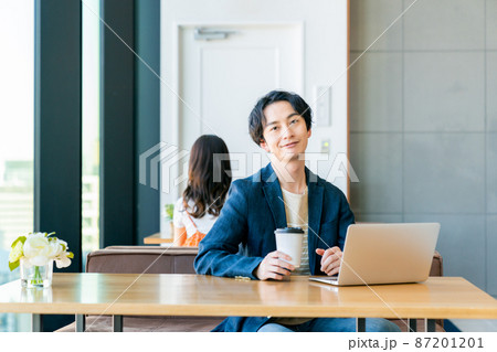 カフェでテレワークする若い男性 87201201