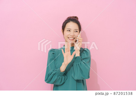 スマホを持つ女性　ピンク背景 87201538