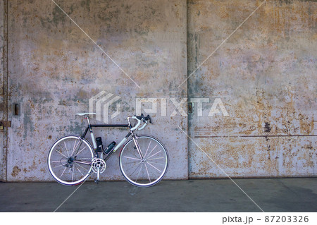倉庫の鉄扉と黒いロードバイク 87203326