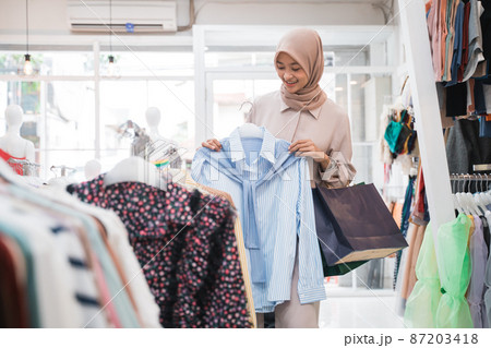 asian muslim woman shopping new clothes before eid mubarak 87203418