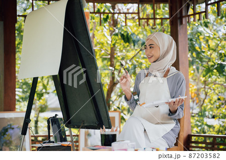muslim Female artist painting on canvas at home studio muslim Female artist painting on canvas at home studio 87203582