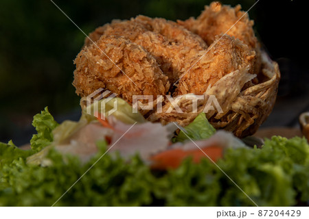 Close-up of Deep-fried shrimp cakes (Tod Mun Goong) and vegetable with chili sauce on wooden background. 87204429