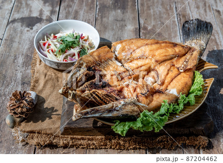 Deep fried Snapper with fish sauce on vintage wooden. Deep fried Snapper with fish sauce on vintage wooden. 87204462