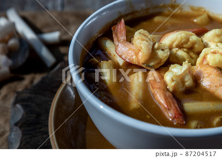 Close-up of Sour soup with lotus stem and shrimps (kaeng som koong with lotus stem), Thai food. Close-up of Sour soup with lotus stem and shrimps (kaeng som koong with lotus stem), Thai food. 87204517