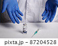 Doctor Presents Covid Vaccine and Syringe - Inoculation Set 87204528