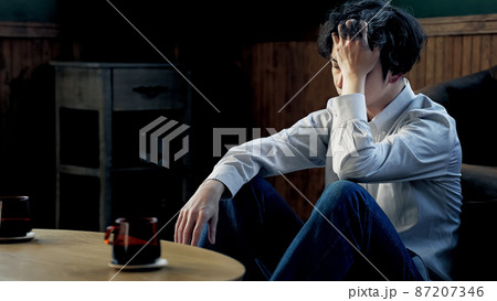 部屋で落ち込む男性 87207346