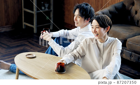 部屋でくつろぐカップル 87207350