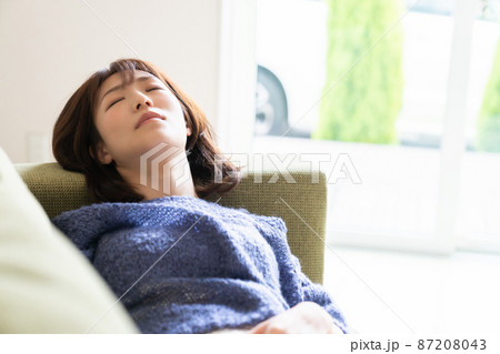 ソファで眠る女性 87208043