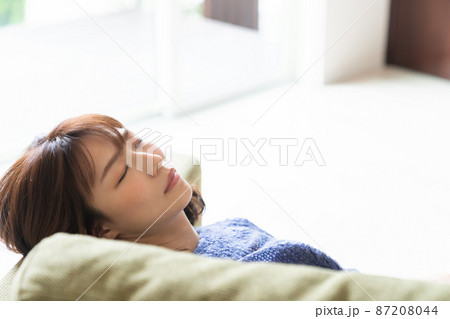 ソファで眠る女性 87208044