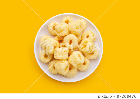Roller corn snack on yellow background. 87208476