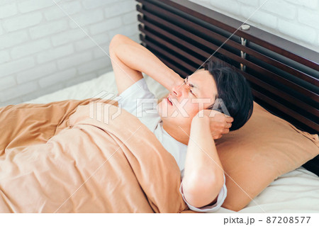 ベッドルームにいる男性（耳が痛い） 87208577