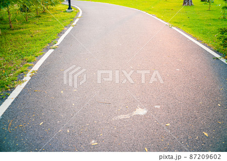 Empty asphalt pathway road in city park sunset 87209602