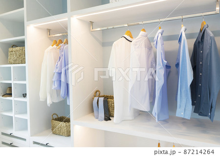 A Large White Built-in Wardrobe Stocked With Clothing, Shoes and Accessories. Walk-in closet, Dressing Room. 87214264