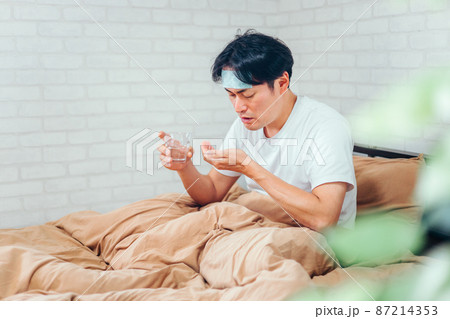 薬を飲む男性 87214353