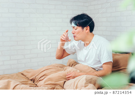 薬を飲む男性 87214354