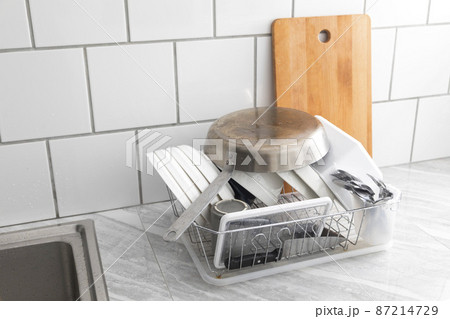 Set of fresh washed plates and cutlery board on the kitchen counter. 87214729