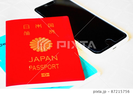 白を背景に置かれたパスポート、スマートフォン 白を背景に置かれたパスポート、スマートフォン 87215756