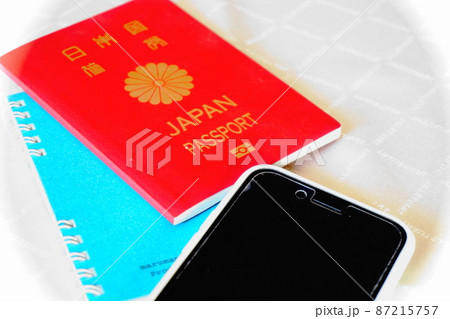 白を背景に置かれたパスポート、スマートフォン 87215757