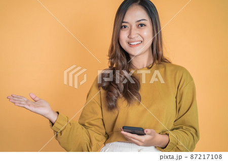woman using mobile phone with presenting copyspace on the palm 87217108