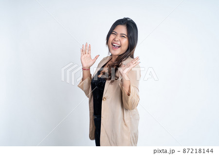 Excited young asian woman opening two palms while smiling 87218144