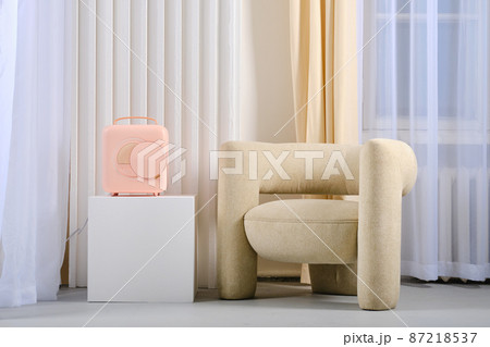Mobile mini refrigerator near cozy armchair, portable fridge Mobile mini refrigerator near cozy armchair, portable fridge 87218537