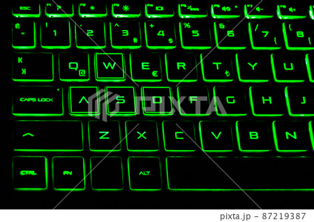 A black color laptop and Q keyboard green light detail A black color laptop and Q keyboard green light detail 87219387