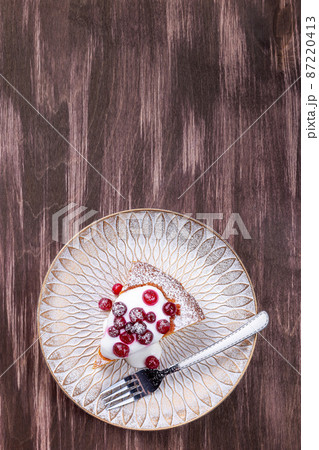Plate with piece of Swedish saffron Kladdkaka pie, vertical, top view, copy space 87220413