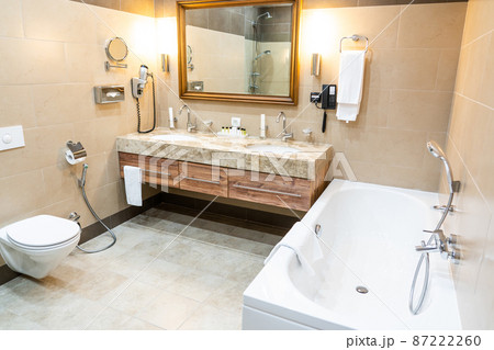 Luxury bathroom with brown tiles and two sinks Luxury bathroom with brown tiles and two sinks 87222260