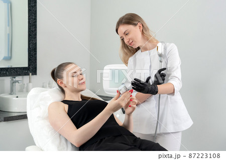 Young woman receiving laser treatment in cosmetology clinic 87223108