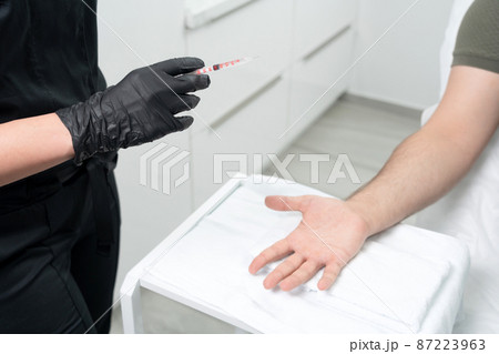 doctor makes a shot of botulinum toxin in the hand of a male palm against excessive sweating, treatment of hyperhidrosis 87223963